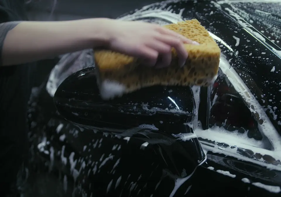 Lavage à l’éponge d’un rétroviseur couvert de mousse